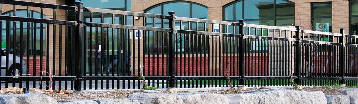 A black metal fence surrounds a building.