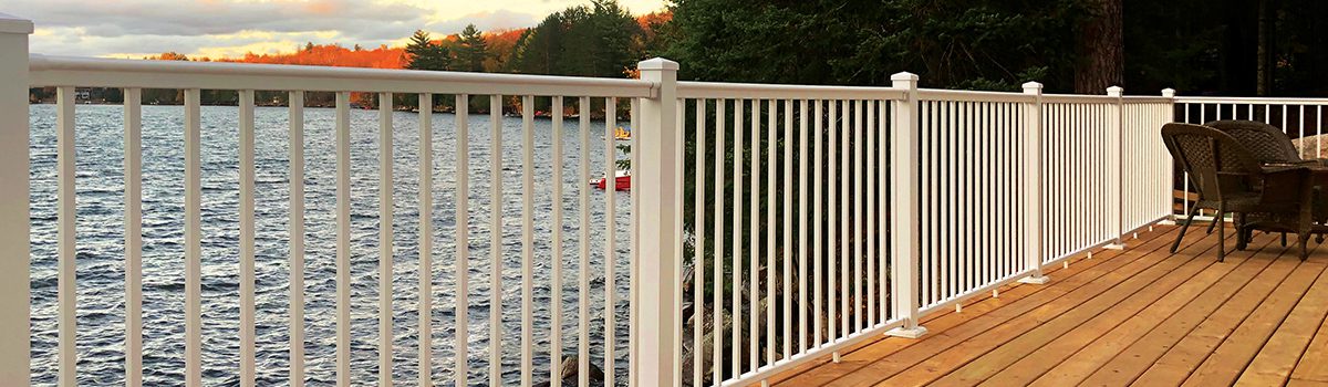 Deck with white metal railings and a water view.