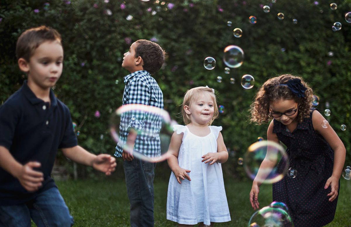 Kids play with bubbles in the backyard.