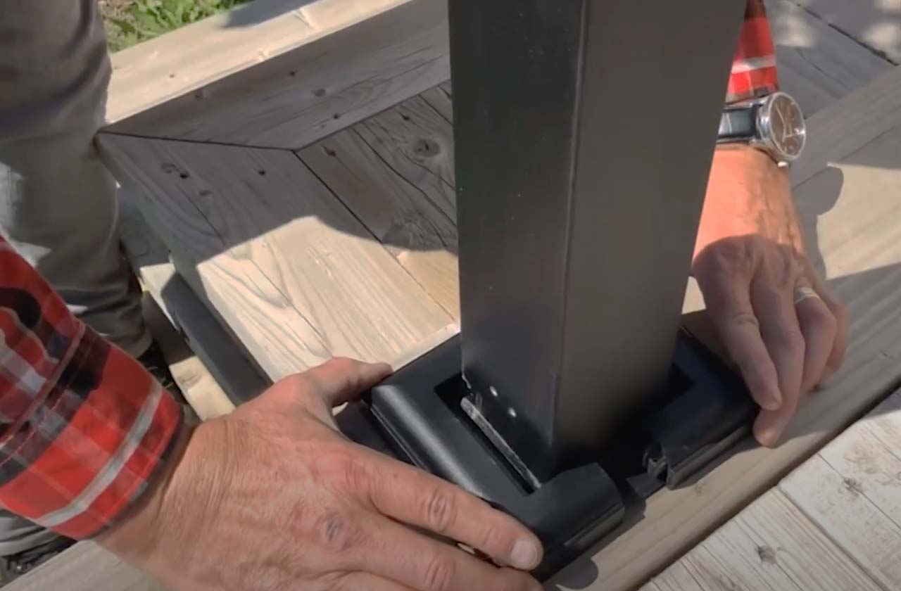 A worker installs trim around an aluminum deck rail.