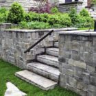Luxury landscaping features a retaining wall and natural stone steps and stepping stones.