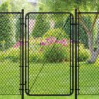 Black chain-link fence with a matching walk-through gate installed in a backyard, surrounded by a willow tree, evergreen shrubs, and blooming pink flowers on a green lawn.