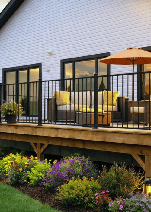 Black steel Ready Rail DR3470-STB railing panel installed on a raised deck with outdoor furniture at sunset