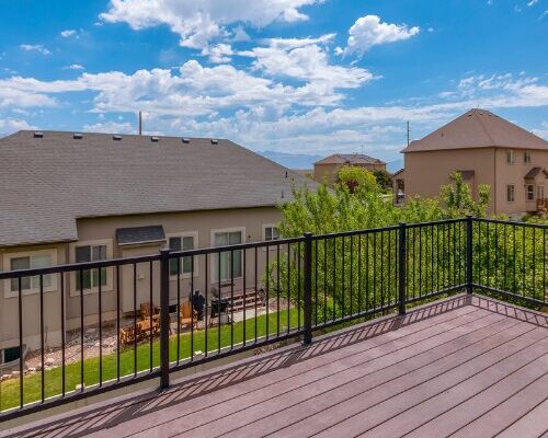 nuvo iron deck railing black metal fencing system with vertical balusters on elevated composite deck overlooking backyard