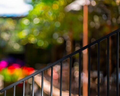 nuvo iron stair railing black metal fencing with vertical balusters on outdoor steps with blurred garden background