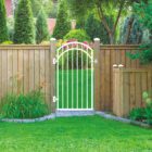 nuvo-iron-white-gate-kit-installed-in-wooden-fence-in-backyard-setting